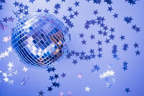 Disco ball with rays on neon blue. Creative pattern with copy space. Stock Photos