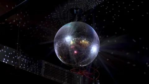 A disco ball rotating on the ceiling of the night club and reflects rays of Stockbeeldmateriaal 288866225