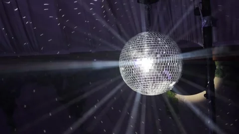 Disco ball spins and reflects bright lights during a celebratory dance event Stock Footage 331212876