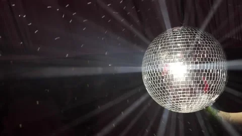 Disco ball spins and reflects bright lights during a celebratory dance event Stock Footage 339179715
