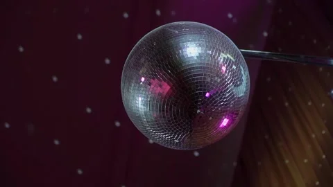 A disco ball suspended from the ceiling rotates quickly, light rays and glare. Stockbeeldmateriaal 277167504