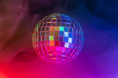 Disco ball in vibrant, colored light, reflecting hues, reminiscent of dance c Stock Photos