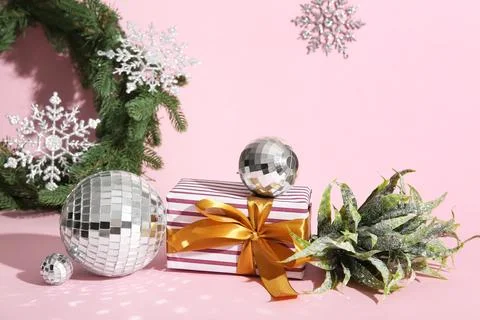 Disco balls with Christmas gift box on pink background Stock Photos