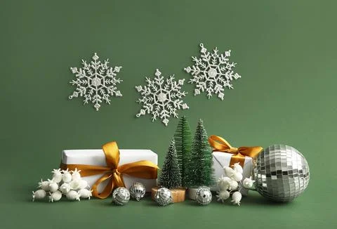 Disco balls, gift boxes and Christmas decor on green background Stock Photos
