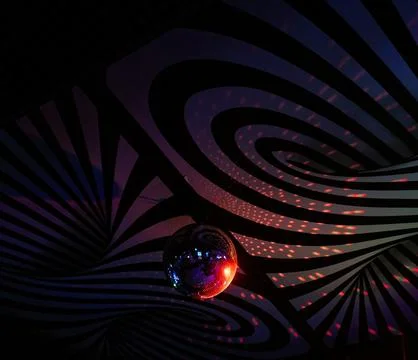 Disco balls hanging from the ceiling in front of a rainbow colored pattern Stock Photos