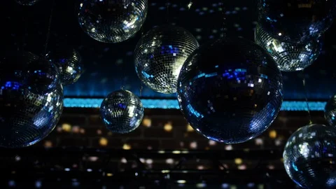 Disco balls spin reflecting coloured light on brick wall Video stock 108583219