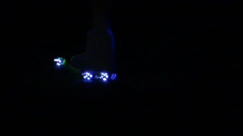 Disco roller blading  in the dark with blue lights on roller blades Stock Footage 115675180