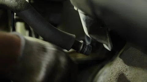 A disconnected rubber hose with fitting inside a car engine bay. Stock Footage 338365482