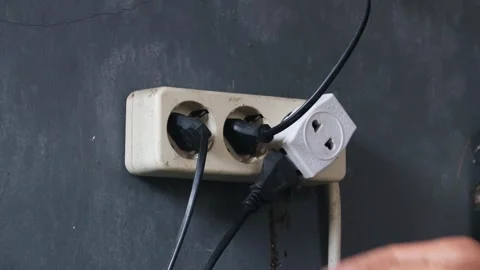 Disconnecting multiple electrical plugs from a wall outlet Stock Footage 337446343