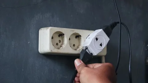 Disconnecting multiple electrical plugs from a wall outlet Stock Footage 337446350