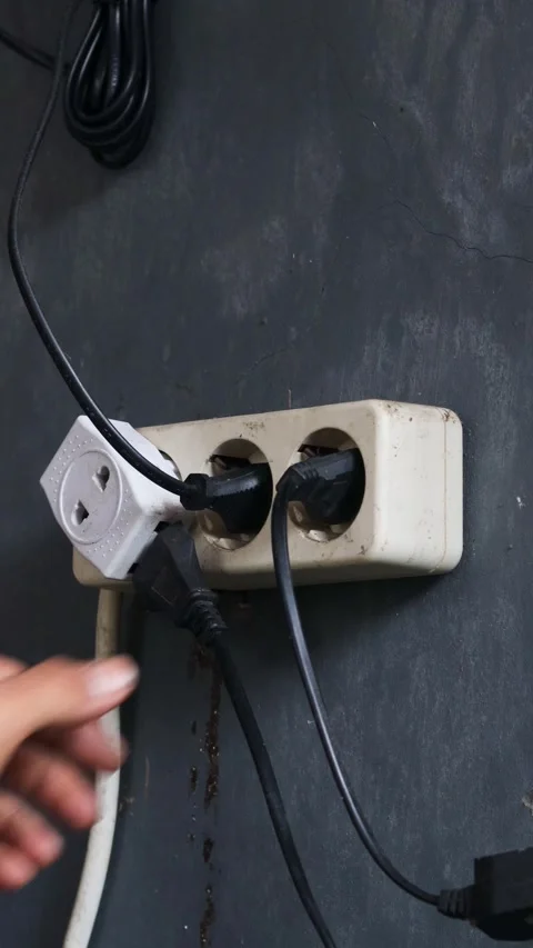 Disconnecting multiple electrical plugs from a wall outlet Stock Footage 337446389