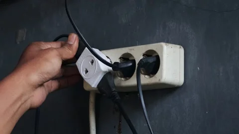 Disconnecting multiple electrical plugs from a wall outlet Stock Footage 337446431