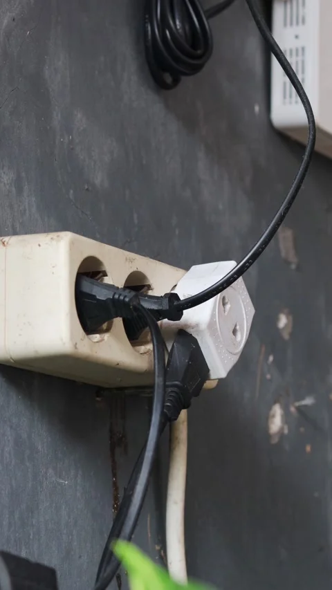 Disconnecting multiple electrical plugs from a wall outlet Stock Footage 337446554