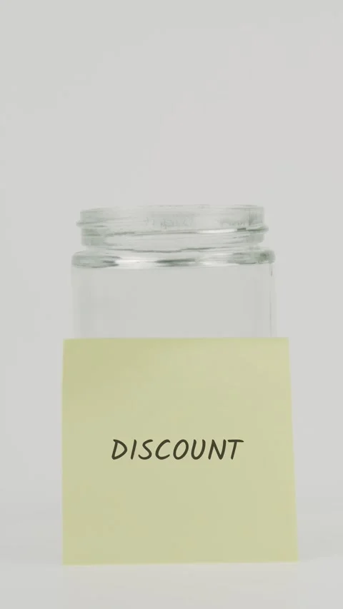 Discount text or word on yellow sticky note attached to glass jar with hand Stock Footage 311719246