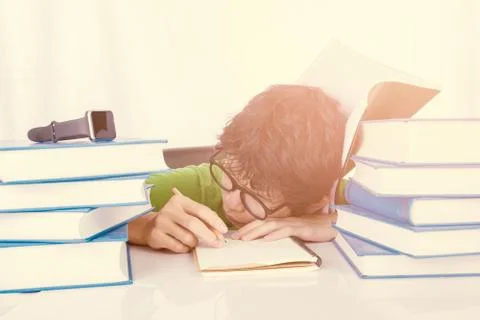 Discouraged student sleep at table in front of his homework Stock Photos