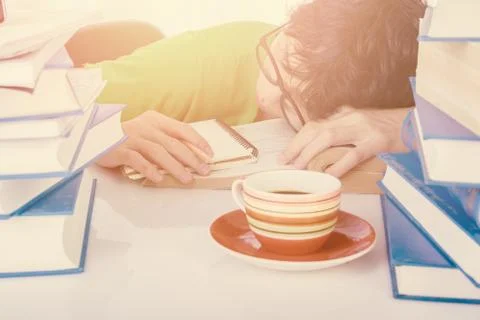 Discouraged student sleep at table in front of his homework Stock Photos