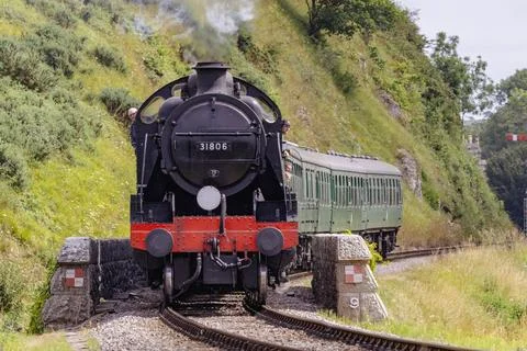 Discover a captivating steam engine moving along a scenic railway track Stock Photos