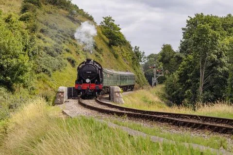 Discover a captivating steam engine moving along a scenic railway track Stock Photos