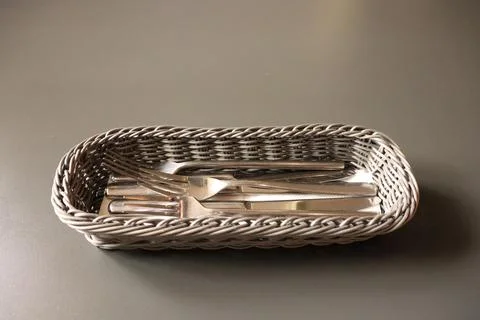 Discover Elegant Silverware Presented Beautifully in a Tasteful Woven Basket Stock Photos