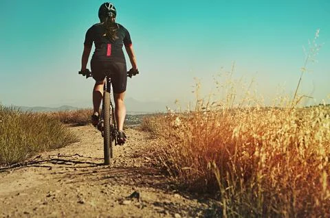 Discover the essence of mountain biking. an adventurous woman out cycling in the Stock Photos