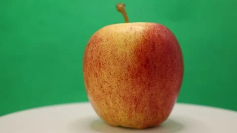 Discovering the beauty of a vibrant apple placed on a bright table against a che Stock Footage 328634456