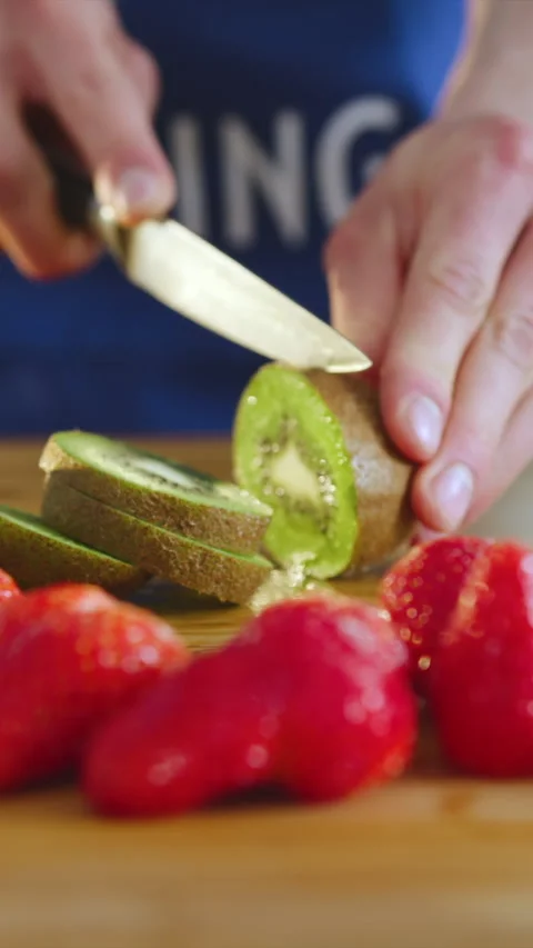Discovering the delicious kiwi while slicing it in the sunny kitchen Stock Footage 341760831