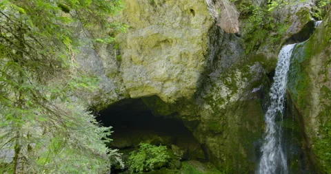 Discovering a hidden cave behind a beautiful waterfall in the forest Stock Footage 314112068