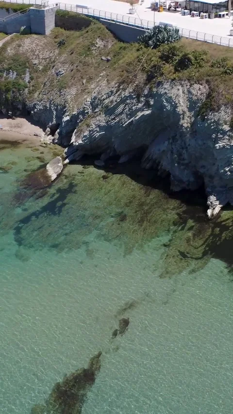 Discovering a Serene Beach With Clear Water and Rocky Cliffs During a Sunny Day Stock Footage 311111356