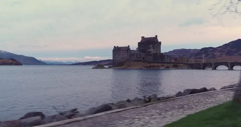 Discovery by Eilean Donan Castle, slow panning shot over water drone aerial 4K Stock Footage 104584539