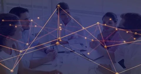 Discussing data flow, professionals collaborating around office conference table Stock Photos