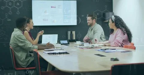 Discussing data four professionals analysing charts around conference table,  Stock Photos