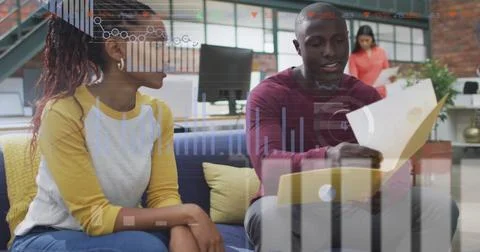 Discussing documents, colleagues in office with data processing image over them Stock Photos
