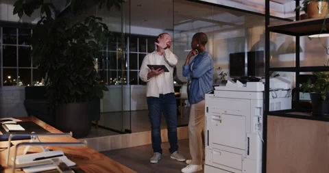 Discussing documents near office printer, business diverse professionals working 動画素材 315973155