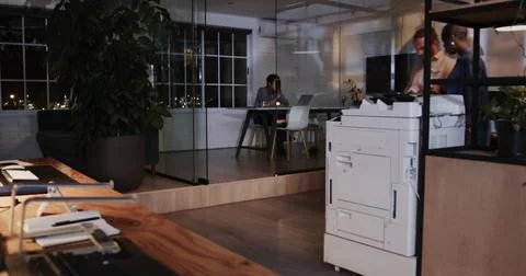Discussing documents near office printer, business diverse professionals working 写真素材