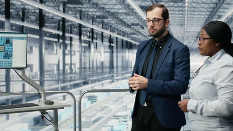 Discussing, microchip and female manager with researcher in production facility Stock Footage 333385115