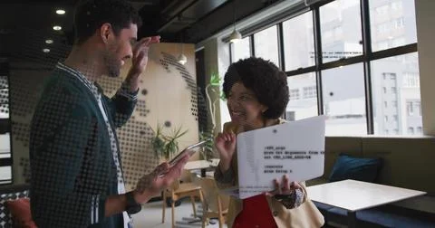 Discussing pair sharing printed code and tablet in coworking office, beige Stockfoto's