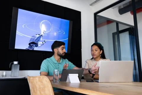 Discussing robotics, colleagues using laptops and tablet in modern office 스톡 사진