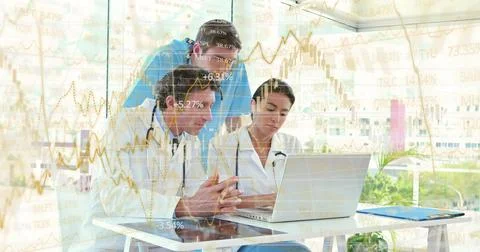 Discussing three doctors typing on laptop in clinic, wearing lab coats, showing Stock Photos