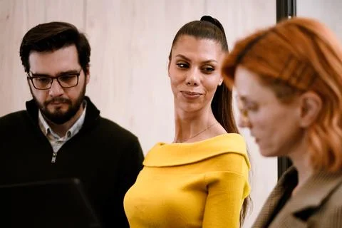Discussion among professionals in an office setting with one woman in a yellow Stock Photos