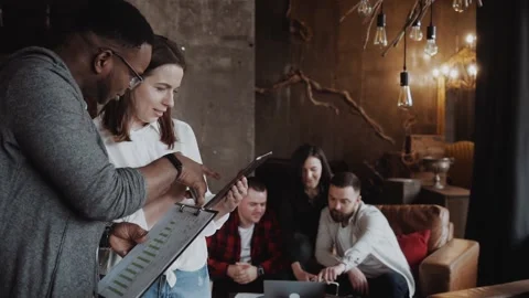 Discussion of a black guy and a white woman in an loft office interior, young Video stock 134899341