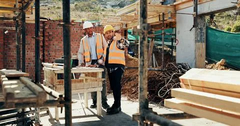 Discussion, men and construction workers on site with planning for property Stock Photos