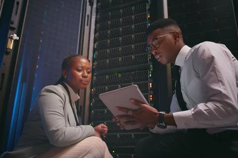 Discussion, team or engineer with tablet by server rack, upgrade planning or Stock Photos