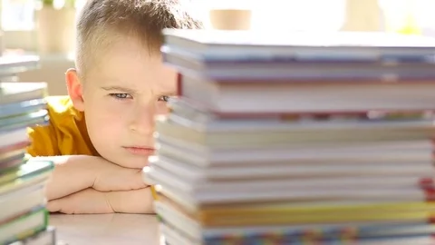  disgruntled boy looking at books Stock Footage 79896083