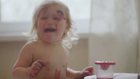 A disgruntled two-year-old child gets dirty with paints Video stock 153550147