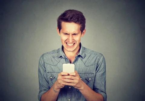Disgusted man reading a text message Stock Photos