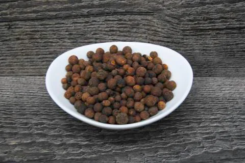 Dish of allspice on rustic background Stock Photos