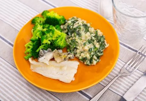 Dish of cod fillet, pearl barley and stewed broccoli Stock Photos