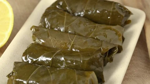 Dish with cold stuffed vine leave rolls with rice and herbs close up Stock Footage 172142451
