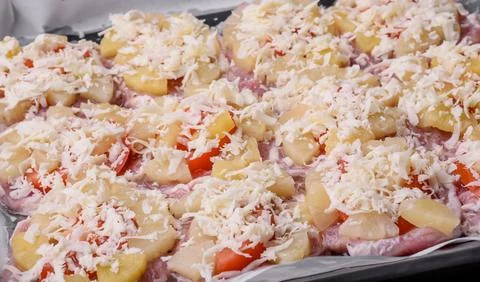 A dish consisting of meat, tomatoes, pineapple, cheese, spices and herbs Stock Photos