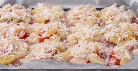 A dish consisting of meat, tomatoes, pineapple, cheese, spices and herbs Stock Photos